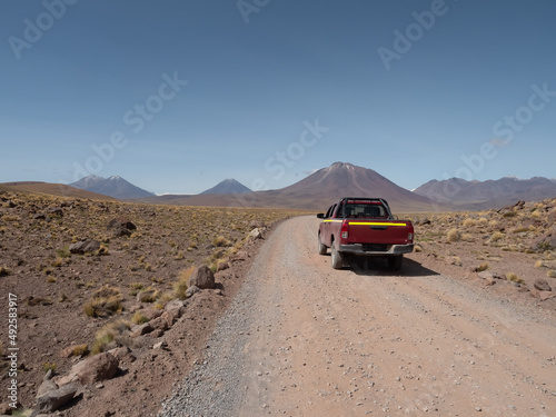 Driving through desert roads in the Atacama desert, among sand dunes and snow-capped volcanos, Chile, near the border with Bolivia and Argentina