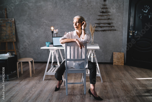 Businesswoman sitting on chair at home art studio