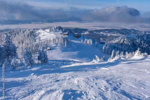 Scenic winter wonderland. Ski resort in full season. Frozen trees covered in snow mountain landscape. Ski cable car challet