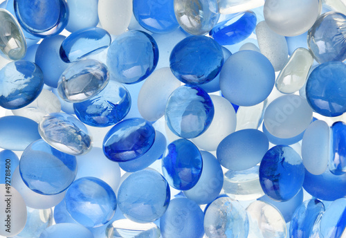 Crystal glass marbles in blue and white color back lit macro shot background texture image 