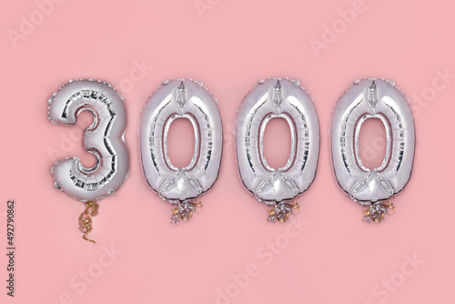 Balloon Bunting for celebration of 3000 made from Silver Number Balloons on pink background. Holiday Party Decoration or postcard concept with top view