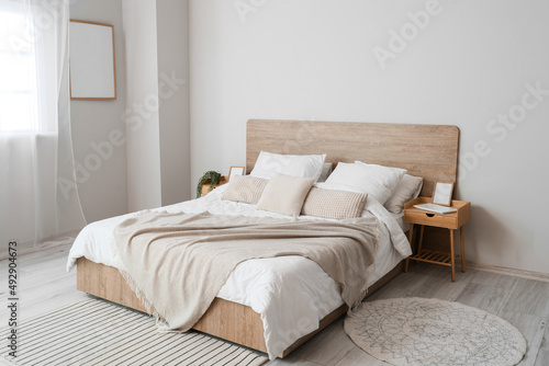 Comfortable bed and nightstands in room