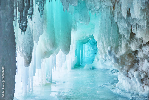 Narrow blue cave of ice in winter