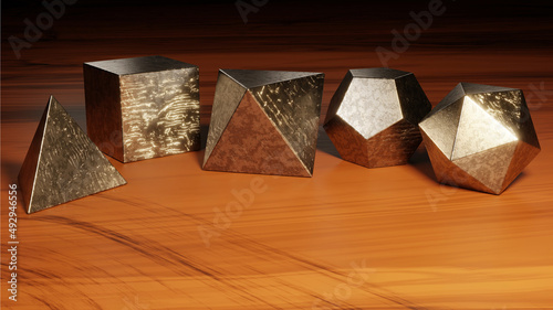 Platonic solids - tetrahedron, cube, octahedron, dodecahedron and icosahedron (set of scratched metal polyhedra on a worn wooden surface)