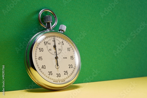 stopwatch against green color background with copy space