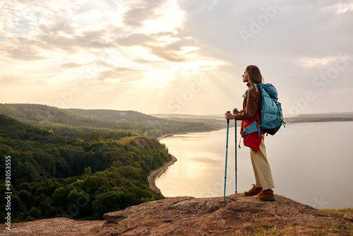 Woman hiking in Autumn mountains, nordic walking and backpacking concept. female traveller in casual wear lead healthy and active lifestyle, outdoors.