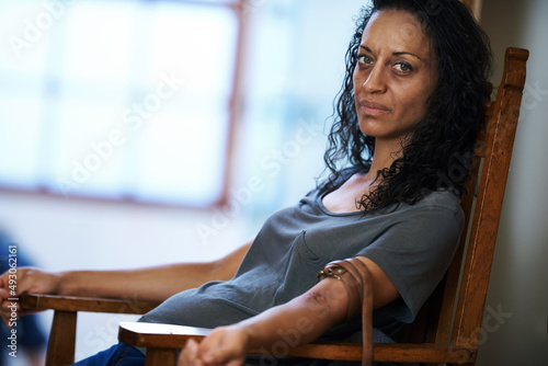 Waiting for change. Portrait of a drug addict sitting in a chair with a belt around her arm.