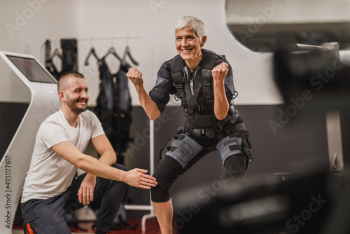 Senior Woman Doing EMS Workout With Coach In The Gym