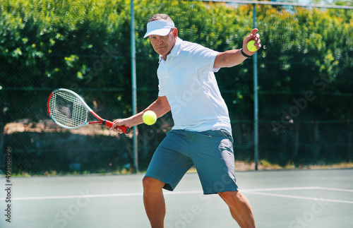 Staying healthy is a lifestyle. Cropped shot of a handsome mature man playing tennis alone on a court during the day.