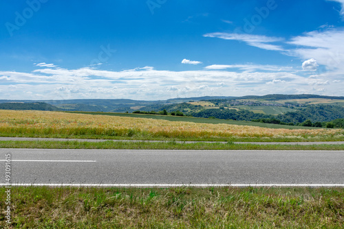 Landstraße durch Felder, Panoramablick auf die Landschaft des Mittelrheintals bei Sankt Goarshausen im Sommer – Country Road in Germany 