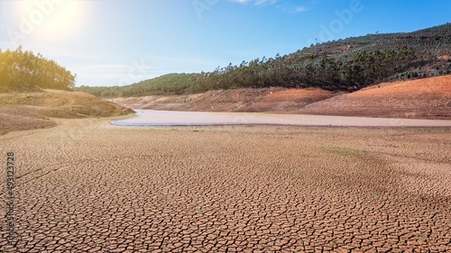 Landscape of low water and dry land in advance, severe drought in the reservoir of Portugal. Ecological disaster, soil dehydration. desert, drought,