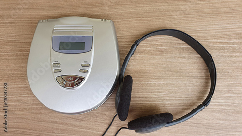 CD player and earphone on wooden background.