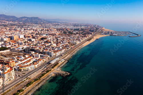 Aerial view of coastal town of Premia de Mar on Catalan coast of turquoise Mediterranean Sea with marina on warm winter day, Maresme, Spain