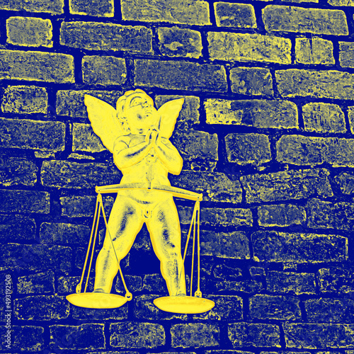 żółty anioł na tle niebieskiego ceglanego muru jako symbol zwycięstwa Ukrainy