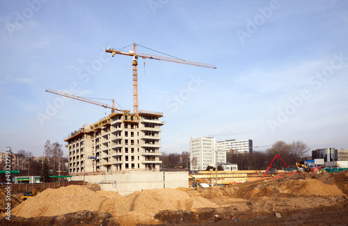 Apartamentowiec w trakcie budowy, szkielet betonowy z dźwigiem budowlanym