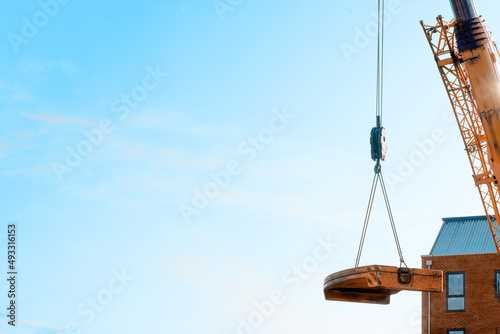 Mobile crane lifting its counterweight during crane assemling and preparations on building site.