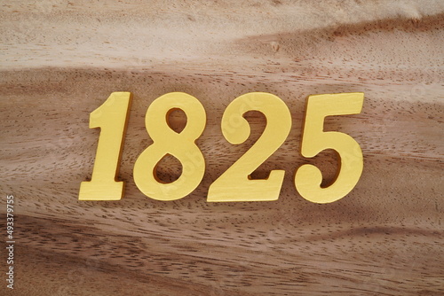 Golden Arabic numerals on a real brown and white wooden floor number 1825