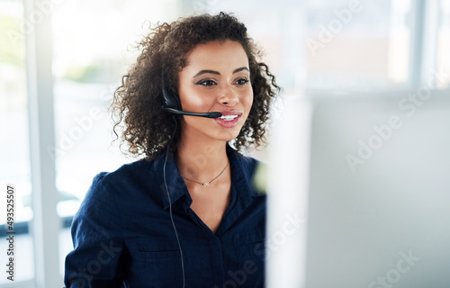 Shes determined to help as many customers as possible. Cropped shot of an attractive young female call center agent working in her office.