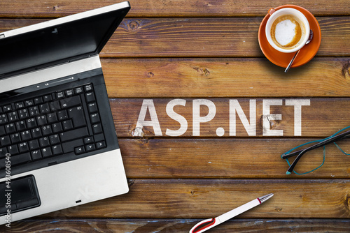 Asp.net programming language. Word asp.net laptop, glasses and coffee on wooden table