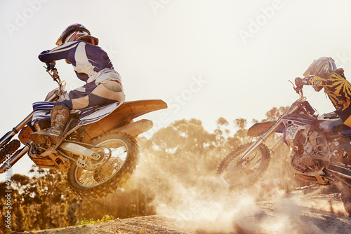 Time to rip up this track. A shot of two dirtbike racers going head-to-head on the track.