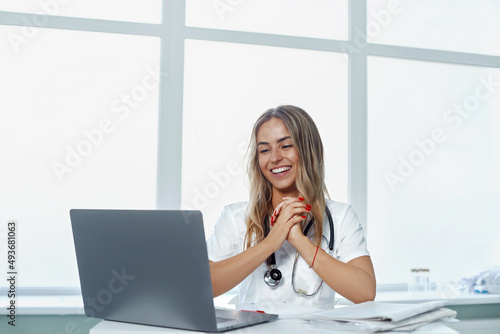 Portrait of a smiling woman doctor, consult patient client online, medicine and technology concept