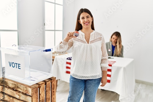 Young american voter woman holding i voted badge standing at electoral college.