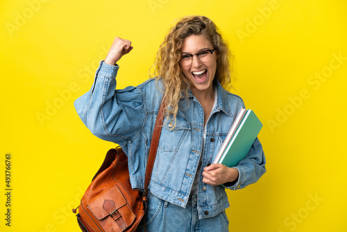 Young student caucasian woman isolated on yellow background doing strong gesture