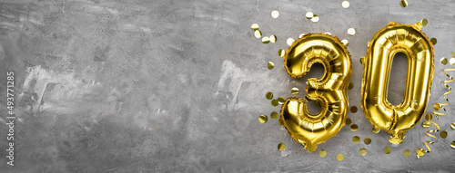 Yellow foil balloon number, number thirty on a concrete background. 30th birthday card. Anniversary concept. for anniversary, birthday, new year celebration. banner