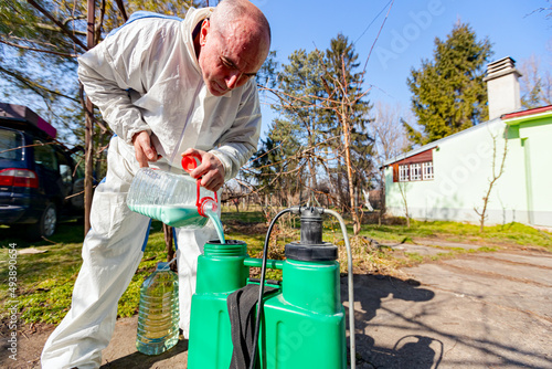 Gardener is blending substance with water in proper scale for sprinkles fruit trees