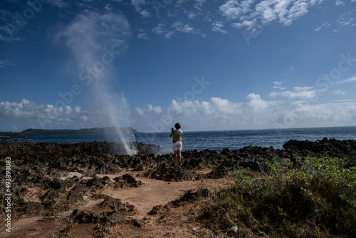 woman tourist near the rocks where the waves of the sea turn into fountains above the ground in the Dominican Republic 