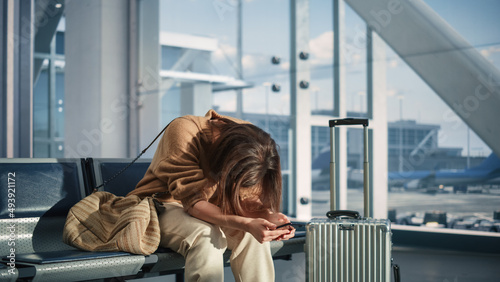 Airport Terminal: Woman Waits for Flight, Uses Smartphone, Receives Bad News, Starts Crying. Upset, Sad, and Dissappointed Person Misses Her Flight while Sitting in a Boarding Lounge of Airline Hub.