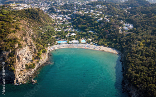Sandy beach in a bay surrounded by hills (aerial drone photo). Ischia island, Italy