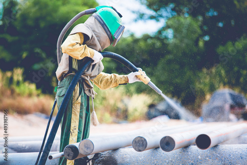 Male worker Sand blasting process cleaning pipeline surface