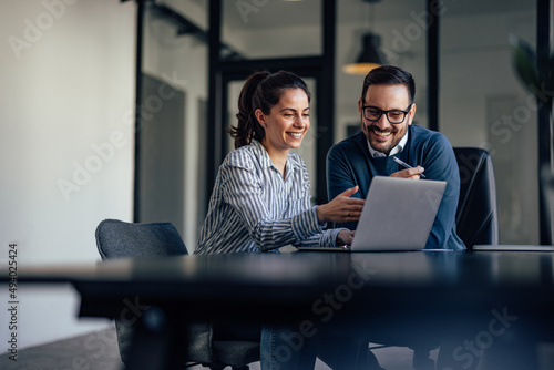 Portrait of two business colleagues, looking at something online.