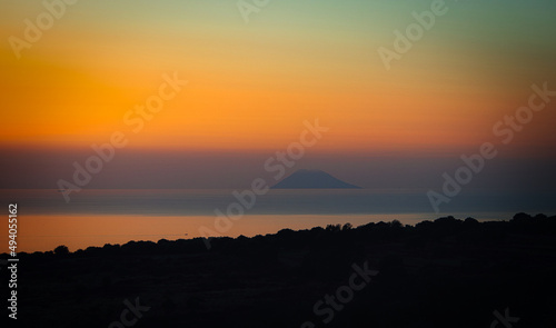 Sunset over the sea with the island of Stromboli in the background.
