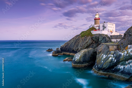 Aerial beautiful view of the Wicklow Head Lighthouse with a sunset sky in the Republic of Ireland