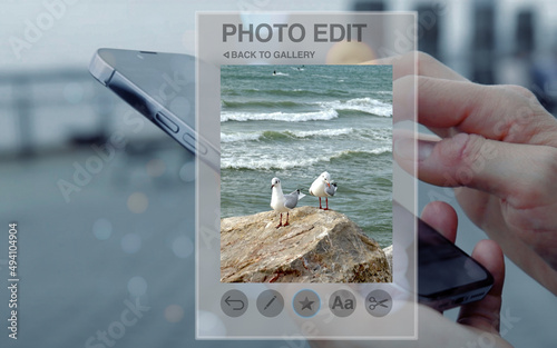 fictitious photo editing app on the smartphone shown as a hologram, while adjust and enhance an image using a smartphone, image editing, cropping, color, brightness, filters, media