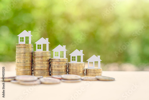 Home loan / reverse mortgage, asset refinancing concept : Small house or home on stacks of coins, depicts a homeowner or a borrower turns properties into cash, saving money to buy shelter, basic need