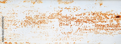 brown grainy rust texture on white metallic background with space for design. panoramic image of a metal wall with cracks, scratches and stained.