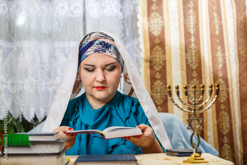 A female rabbi of a Reform Judaism community on Kisui Rosh prays at the table for a siddur.
