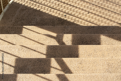 Shadow, patterns on the yellow stone stairs, view on the stairs from the top