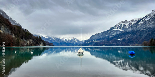 Small boat in the middle of the lake surrounded by Interlaken mountains in Switzerland