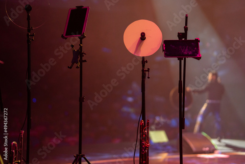 Concierto de charro cantando su música con sombrero en escenario con luces y con instrumentos musicales