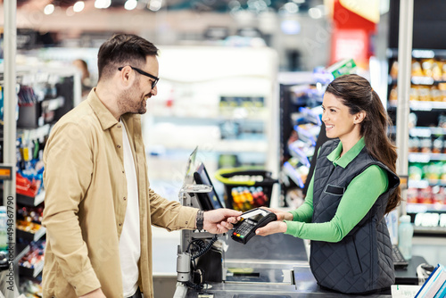 A customer paying at checkout in supermarket.