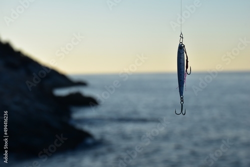 Metal fishing lure and a blur sea background