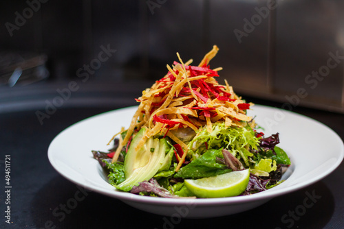 Santa Fe salad tossed in creamy peanut lime dressing topped with tortilla chips and lime wedge