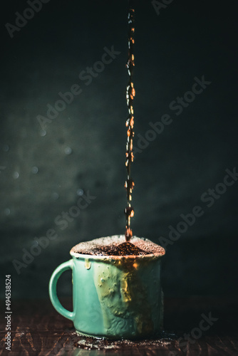 Vertical shot of an overfilled cup of coffee