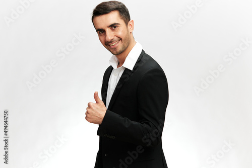 smiling man in black business suit and showing thumb up isolated background Professional success isolated background. Copy space