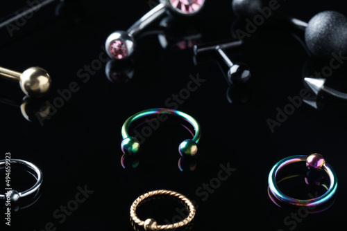 Stylish jewelry for piercing on black background