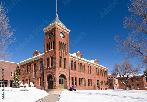 Wide angle image of the historic 1894 red sandstone courthouse building seen under rare fresh snow in winter, Flagstaff, Arizona, USA